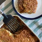 Vegetarian version of Cottage Pie on a green and white stripe cloth next to a plated vegetarian cottage pie